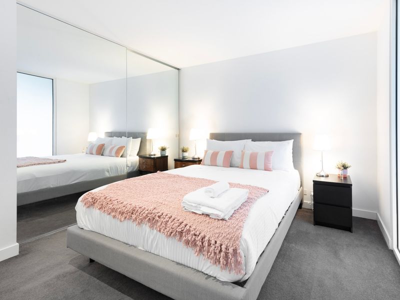 Queen bedroom with mirrored wardrobes and soft lighting