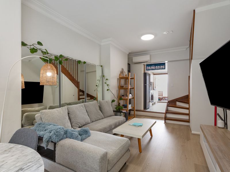 Relax in style with a cozy couch, dining area, and sleek mirrors.