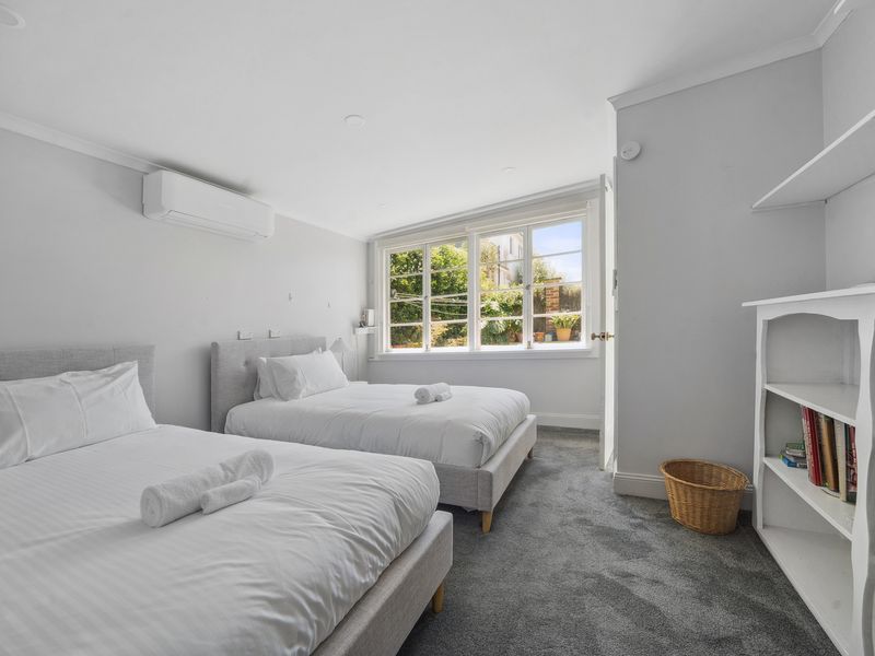 Airy and modern room featuring two cosy single beds.