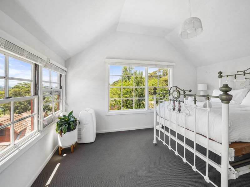 Unique loft bedroom offering character, comfort, and beautiful scenery.