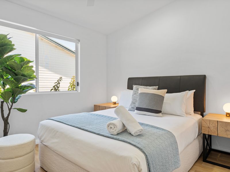 Relax and recharge in the charming third bedroom, featuring a cozy queen bed and stylish decor for a restful stay.