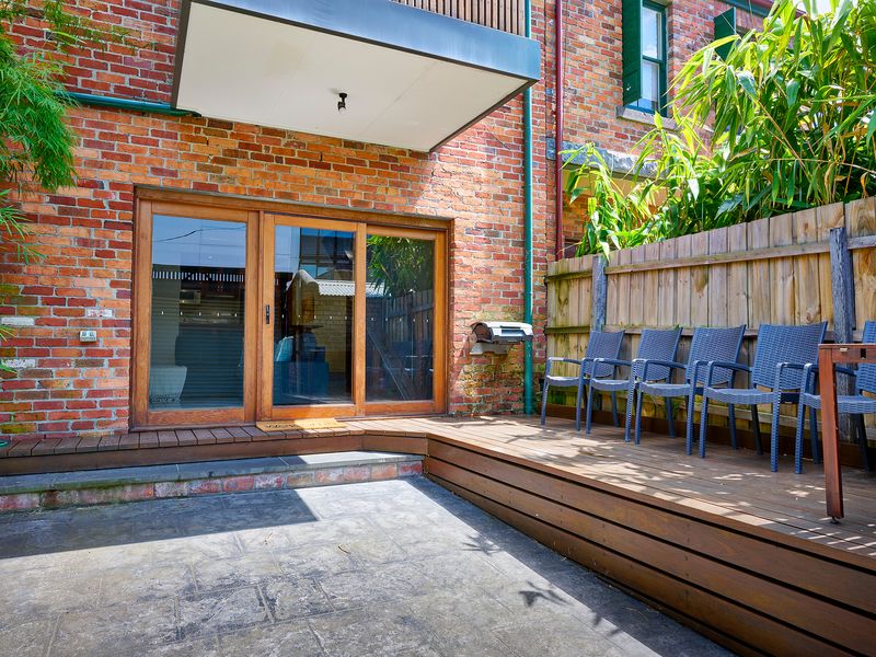 Private Courtyard: Secluded brick patio and raised timber decking ideal for quiet al fresco relaxation.