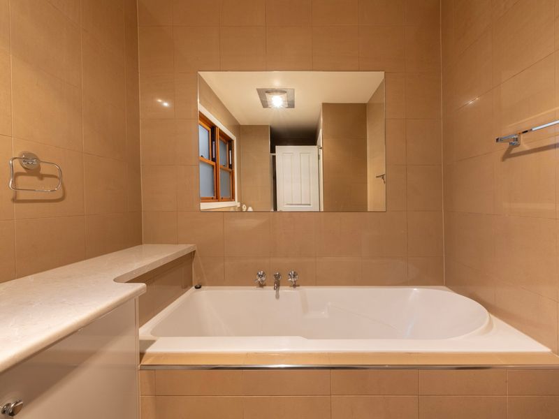 Deep Soak Tub: An elegant, tiled bathroom zone complete with an inviting built-in bath for ultimate relaxation.