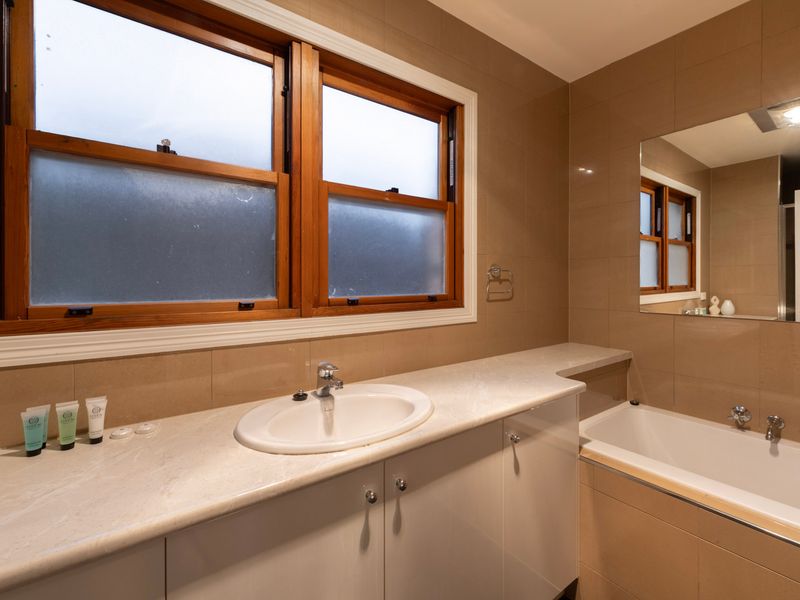 Generous Bathroom: A thoughtfully designed space boasting a long vanity, a separate deep tub, and warm tones.