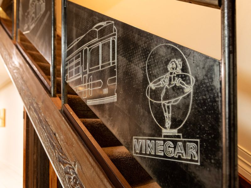 Artistic Heritage: Character-filled timber staircase showcasing unique, custom-etched frosted glass panels.