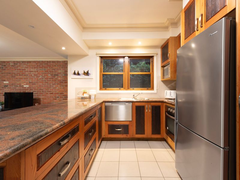 Classic Timber Kitchen: U-shaped kitchen complete with premium stone benchtops and stainless steel appliances.