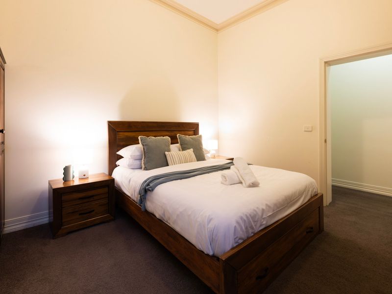 Classic Timber Suite: A bright, inviting layout centered around a matching hardwood bed frame and side tables.