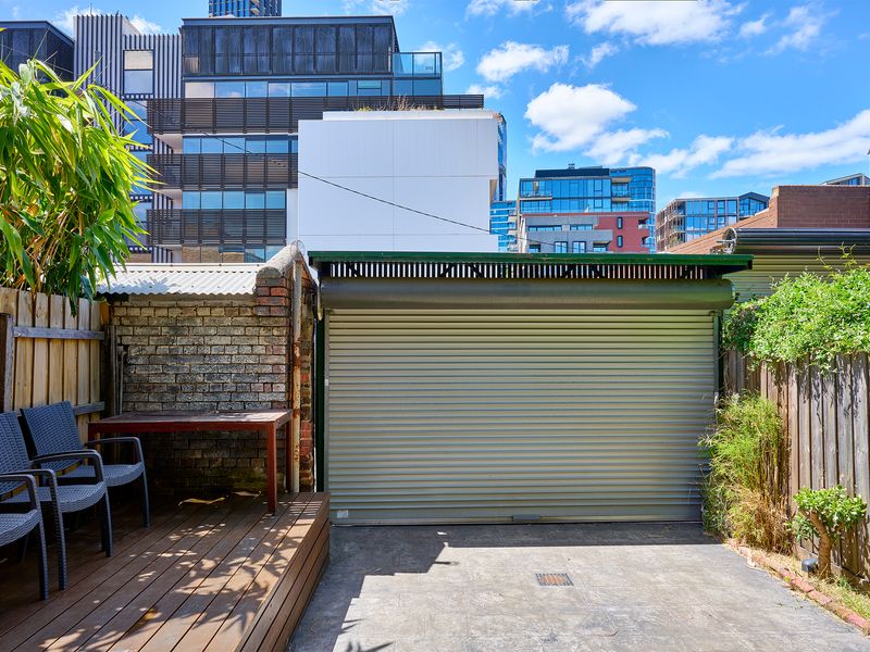 Secure Parking & Patio: A versatile rear courtyard featuring a relaxed timber deck and a secure roller door garage.