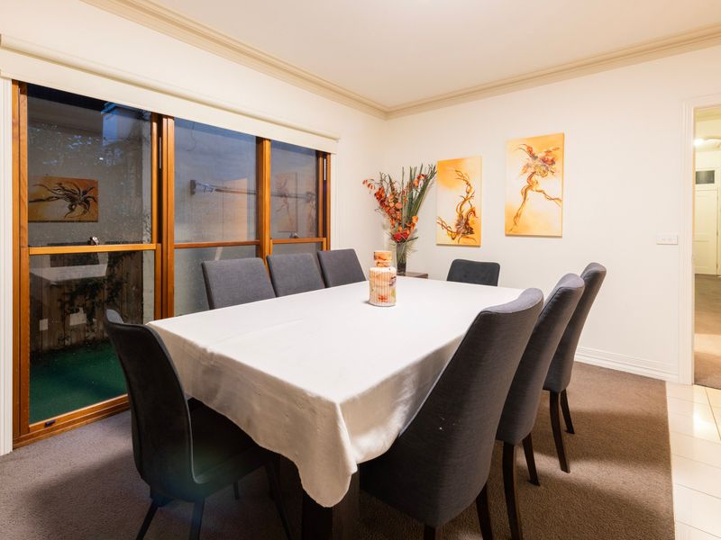 Bright Dining Setup: Sophisticated formal dining area flanked by large timber-framed windows.