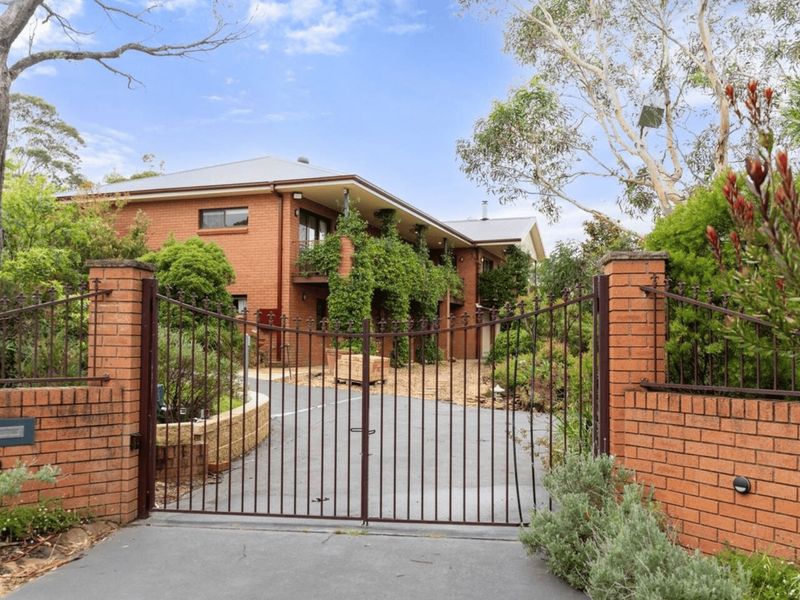 The welcoming entrance with a gated driveway and lush gardens leading you to the property.