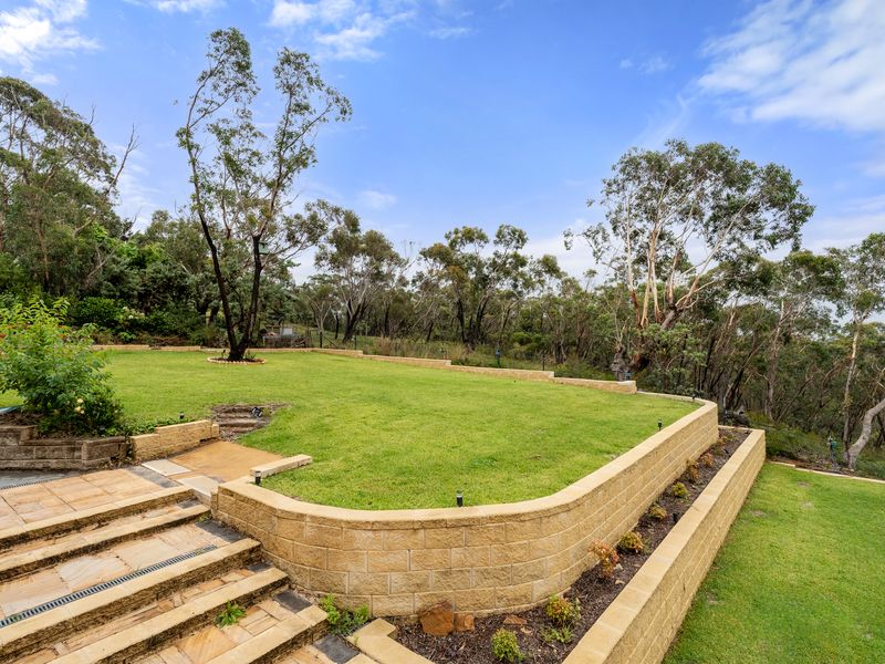 Enjoy the scenic outdoor space with landscaped steps and stunning views of the surrounding trees.