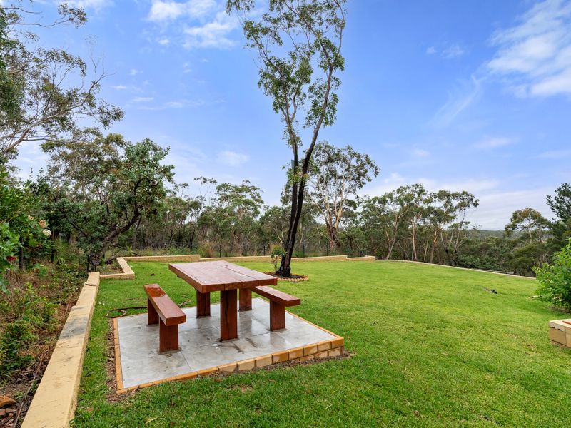 Enjoy the peaceful view and unwind at the outdoor picnic table amidst lush greenery.