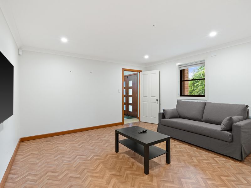 Well-lit living area with comfortable seating, ideal for socializing or enjoying a movie.