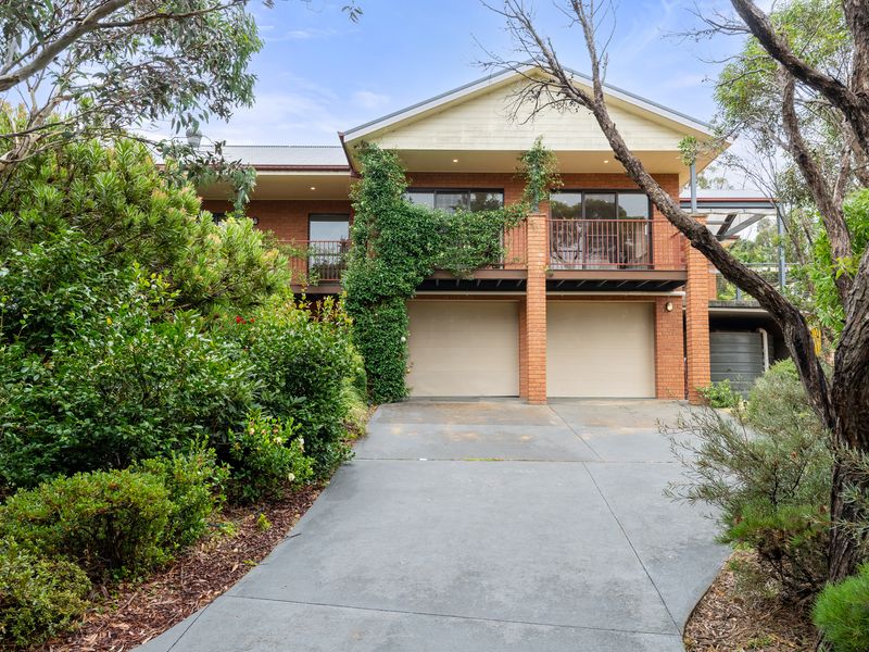 Welcome to this beautiful home with lush gardens and a spacious driveway leading to the entrance.