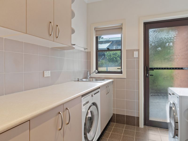 A spacious and well-equipped laundry room with plenty of storage and natural light.