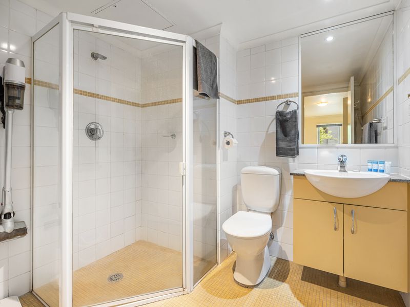 Modern Bathroom with Essentials – A clean and well-lit space featuring a spacious shower and fresh towels.