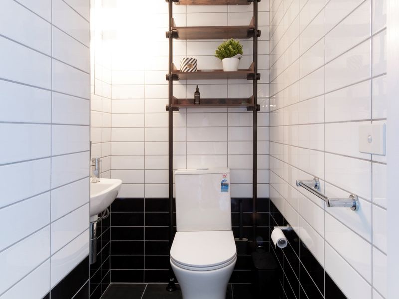 Enjoy a clean, modern bathroom with a minimalist design, featuring a comfortable and functional toilet for your convenience.