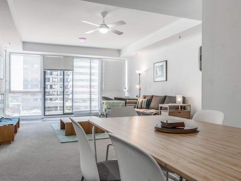 Spacious living and dining area with floor to ceiling windows and city outlooks, creating a bright and inviting atmosphere.