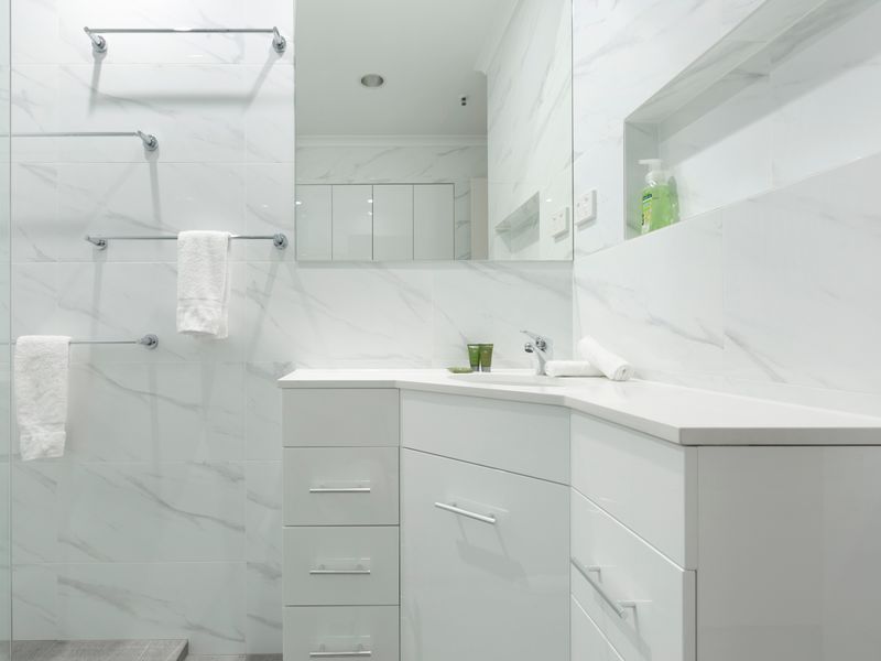 Modern bathroom with large mirror, vanity storage and a clean, minimalist design.