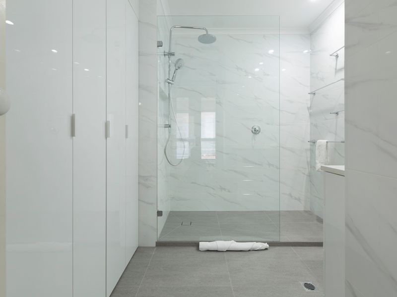 Spacious walk in shower with contemporary fittings and tiled finishes.