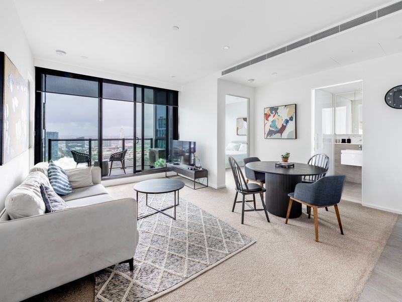 Bright and stylish living room with floor-to-ceiling windows and city views.