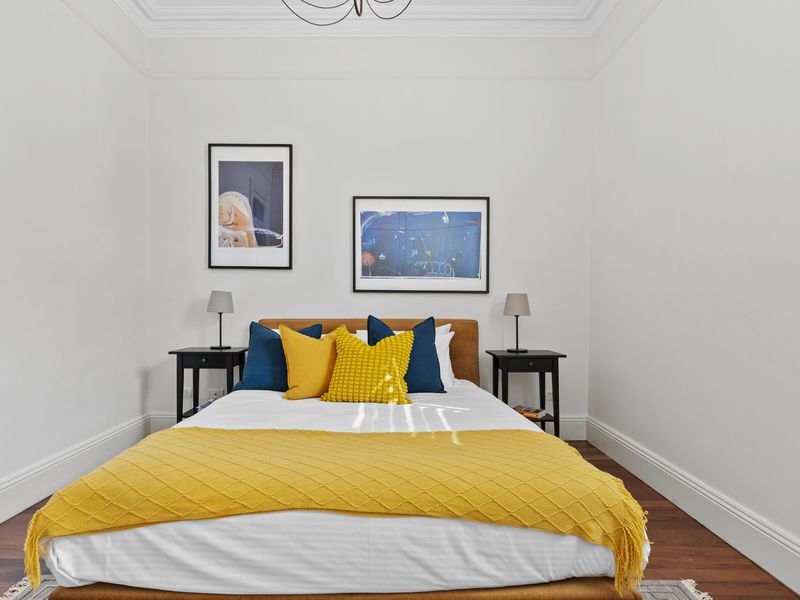 A serene bedroom with plenty of natural light and vibrant touches.