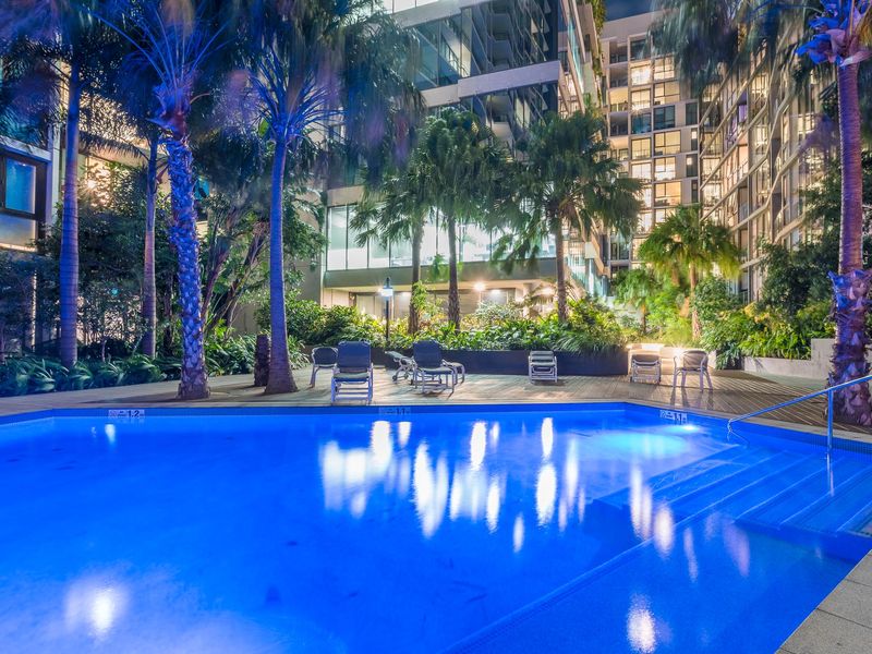 Come evening, the pool glows with dramatic blue accent lighting, creating a luxurious atmosphere perfect for a late-night dip under the city stars. You'll feel like you've checked into a five-star resort without ever leaving home!