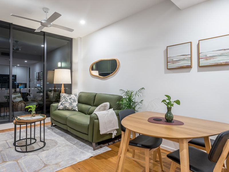 Living Room: Lighting/View: The room features a ceiling fan. Large glass doors at the back look out onto a balcony.