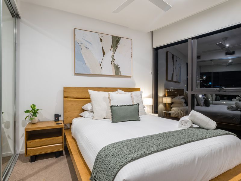 Bedroom 2: Where Rest Meets Retreat. Indulge in the comfort of the plush Queen bed and luxury bedding, surrounded by chic decor and vibrant art. It's your private, stylish haven after a day of adventure.