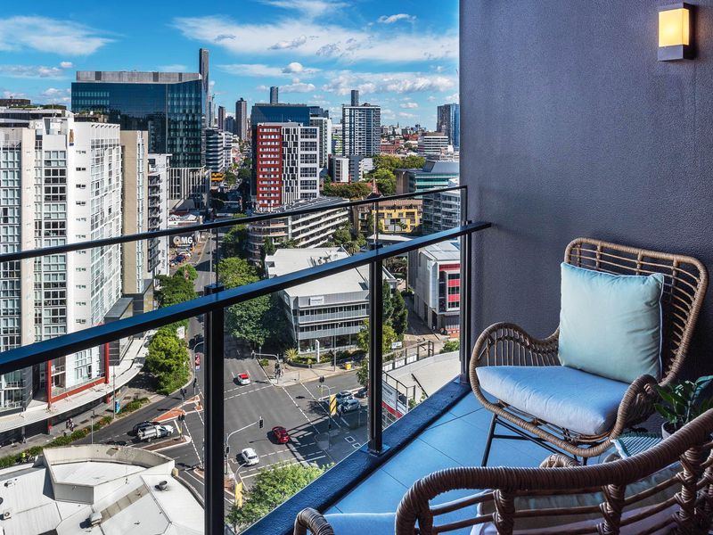A high-rise balcony with views of the Brisbane inner-city area during the daytime.