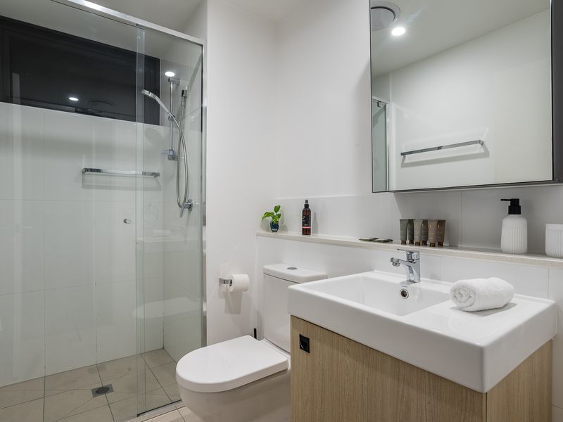 Bathroom: Walk-in Shower: Enjoy a refreshing experience in the glass-enclosed walk-in shower with a modern fixture and clean white tiling.