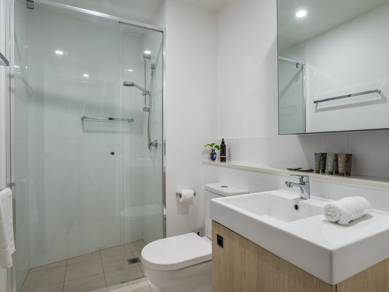 Bathroom: Walk-in Shower: Enjoy a refreshing experience in the glass-enclosed walk-in shower with a modern fixture and clean white tiling.