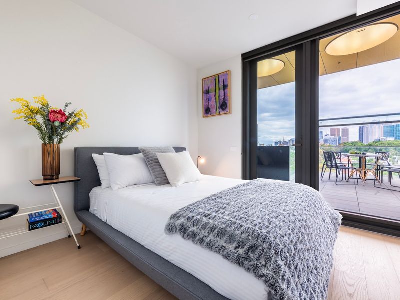 Sunlit bedroom with balcony access, perfect for relaxing mornings.