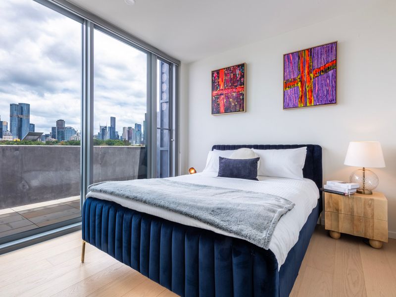 Elegant bedroom with floor-to-ceiling windows and vibrant artwork.