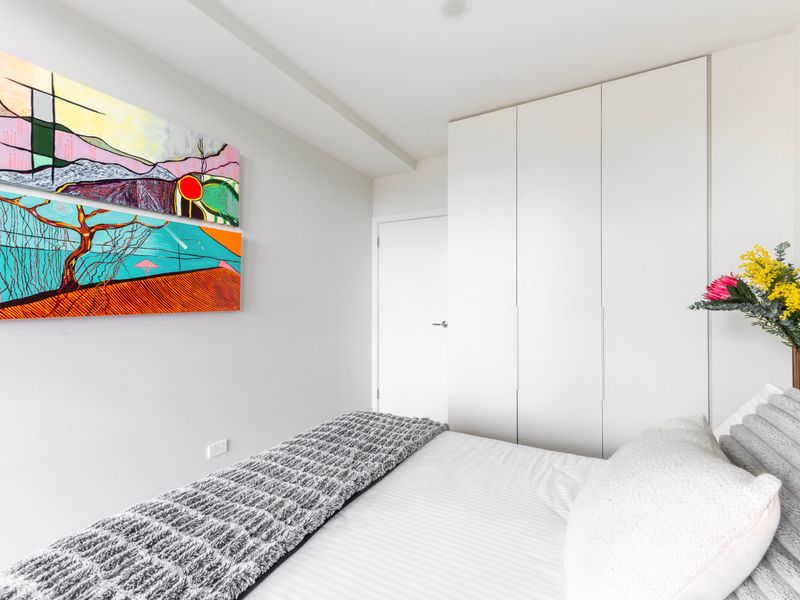 Bright and cozy bedroom with modern art accents and plenty of natural light.