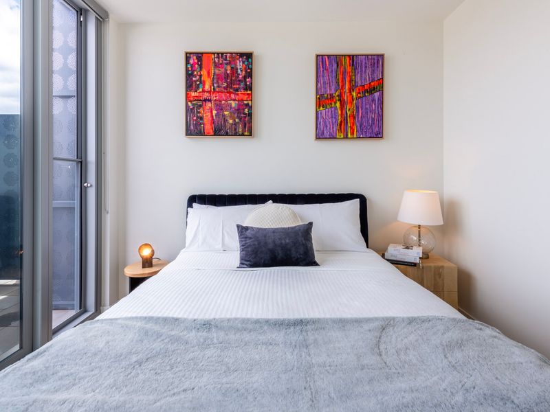 Comfortable bedroom with cozy linens and bright lighting.