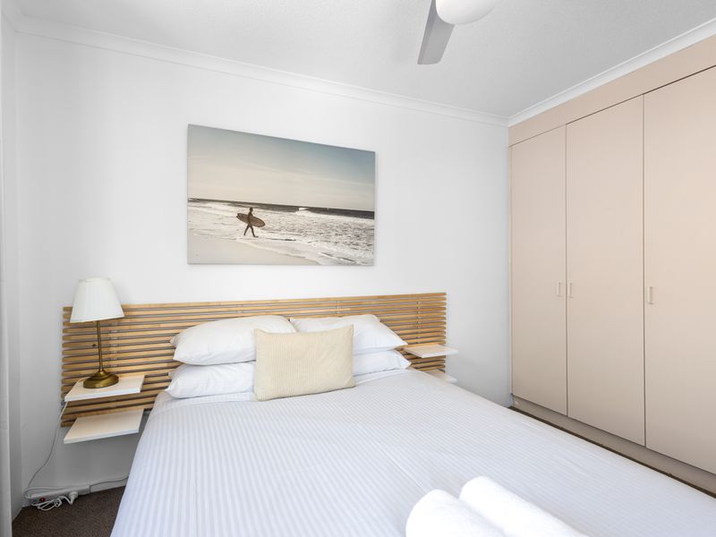 Drift off to sleep in this tranquil space featuring comfortable queen bedding and a relaxed, bright aesthetic. Ample storage is provided by the large, built-in wardrobe for a clutter-free stay.