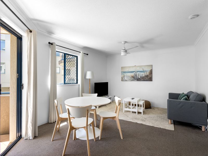 Seamless flow and natural light. The living area opens to a private balcony and includes a four-seater dining table for meals and gathering.