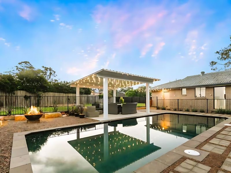 Sparkling pool, cozy firepit, and a beautifully lit outdoor lounge