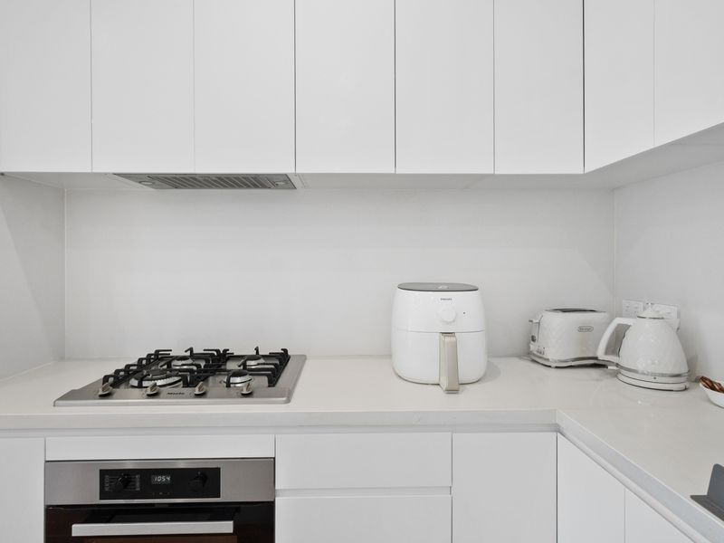 Where culinary adventures begin: A pristine kitchen featuring essential appliances.