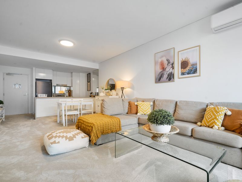 Lounge and dining space opening to a private balcony with an ocean glimpse.