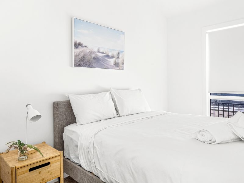 Second bedroom with soft linens and calming decor