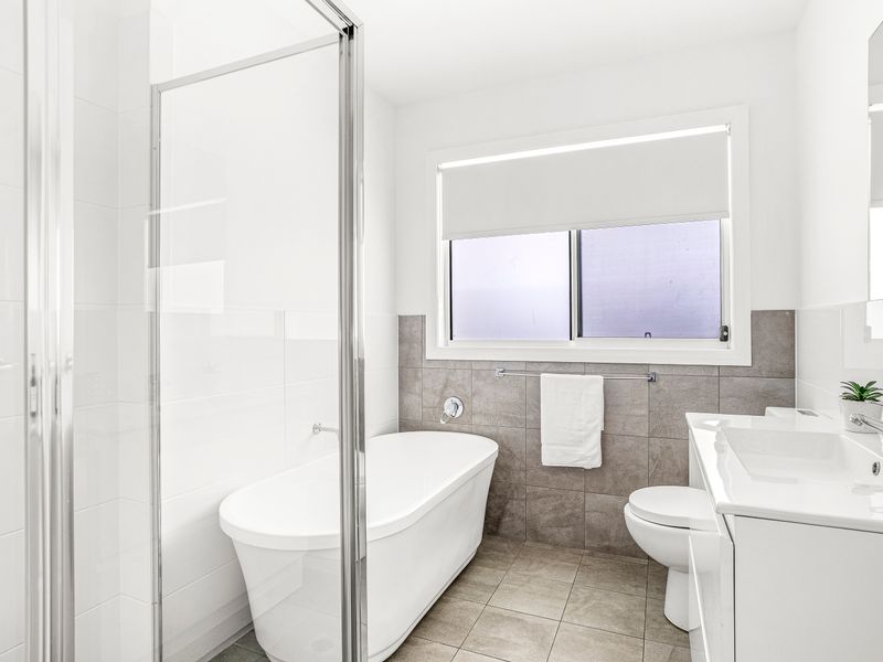Bright modern bathroom with walk-in shower, freestanding tub, and natural light.