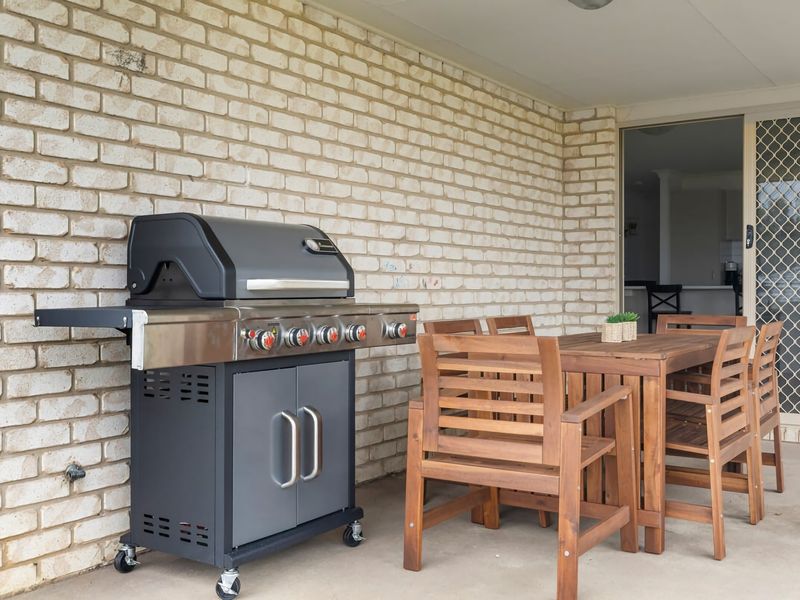 Covered alfresco dining with BBQ and outdoor furniture