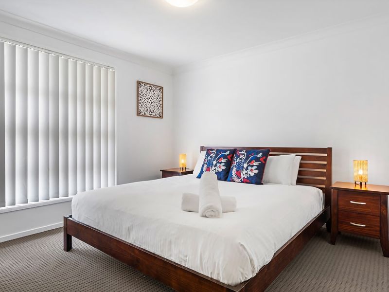 Master bedroom with plush bedding and bedside lighting