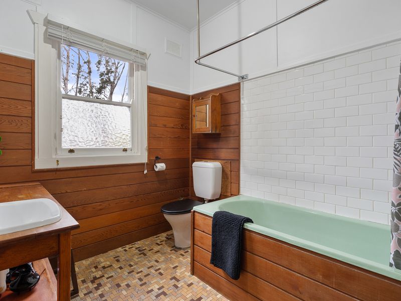 A touch of timeless elegance in every corner. Loving the classic wood paneling and vintage tub!