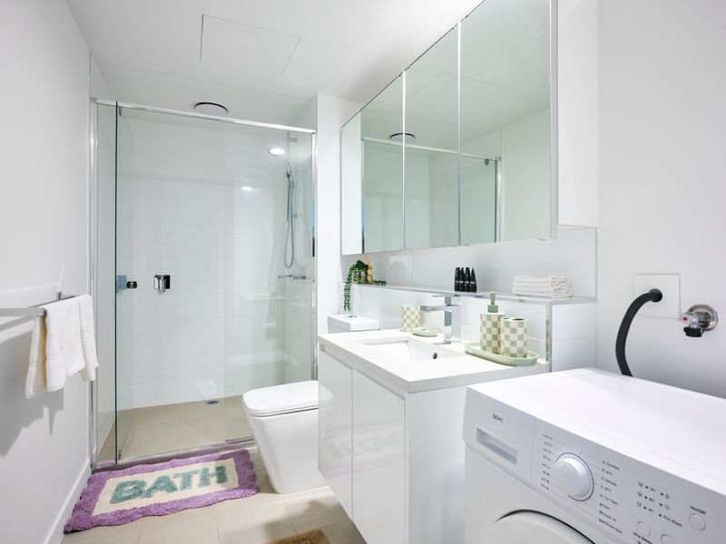 Clean and functional bathroom with laundry facilities.
