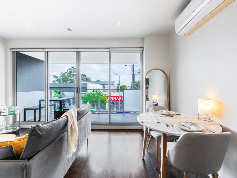 A close-up of the modern and chic decor in the living room, featuring a beautiful throw pillow and warm lighting.