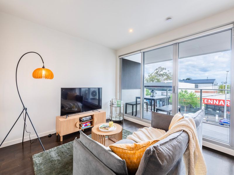 Bright and cozy living area with a flat-screen TV and natural light streaming in through the windows.
