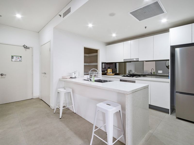 Fully equipped kitchen with island bench and seating.